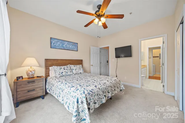 a bedroom with a bed and a lamp on dresser