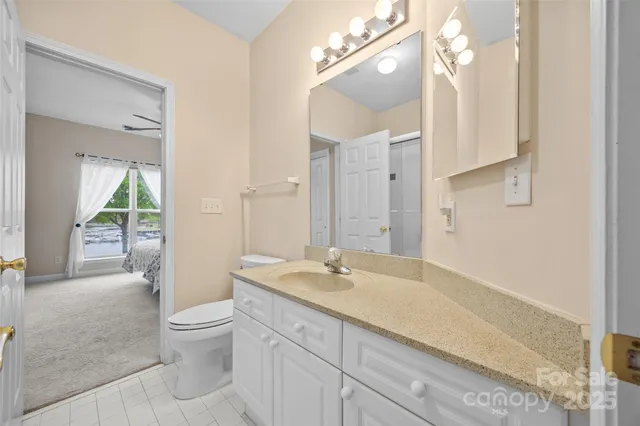 a spacious bathroom with a granite countertop sink a toilet and a shower
