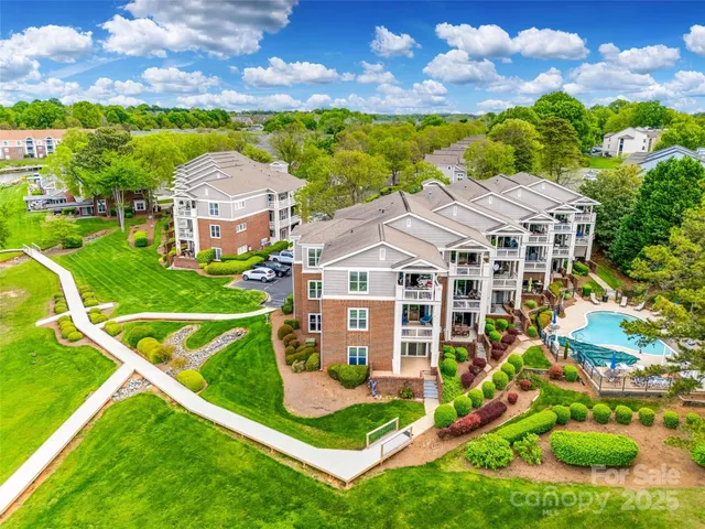 a view of a white house with a big yard and potted plants