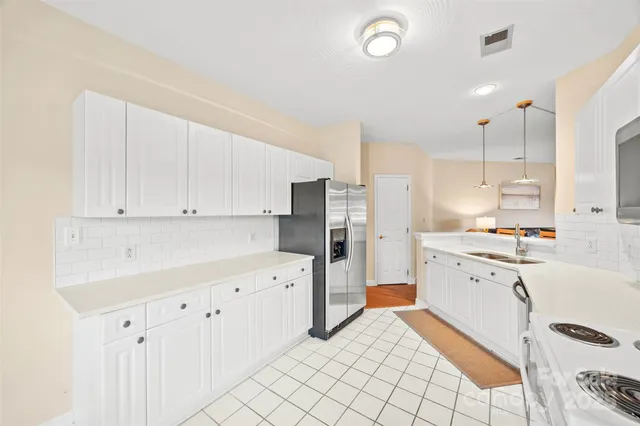 a kitchen with white cabinets and white appliances