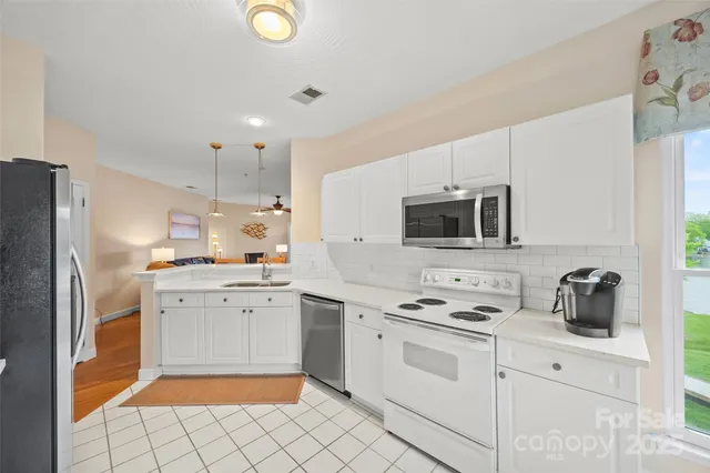 a kitchen with white cabinets stainless steel appliances and sink