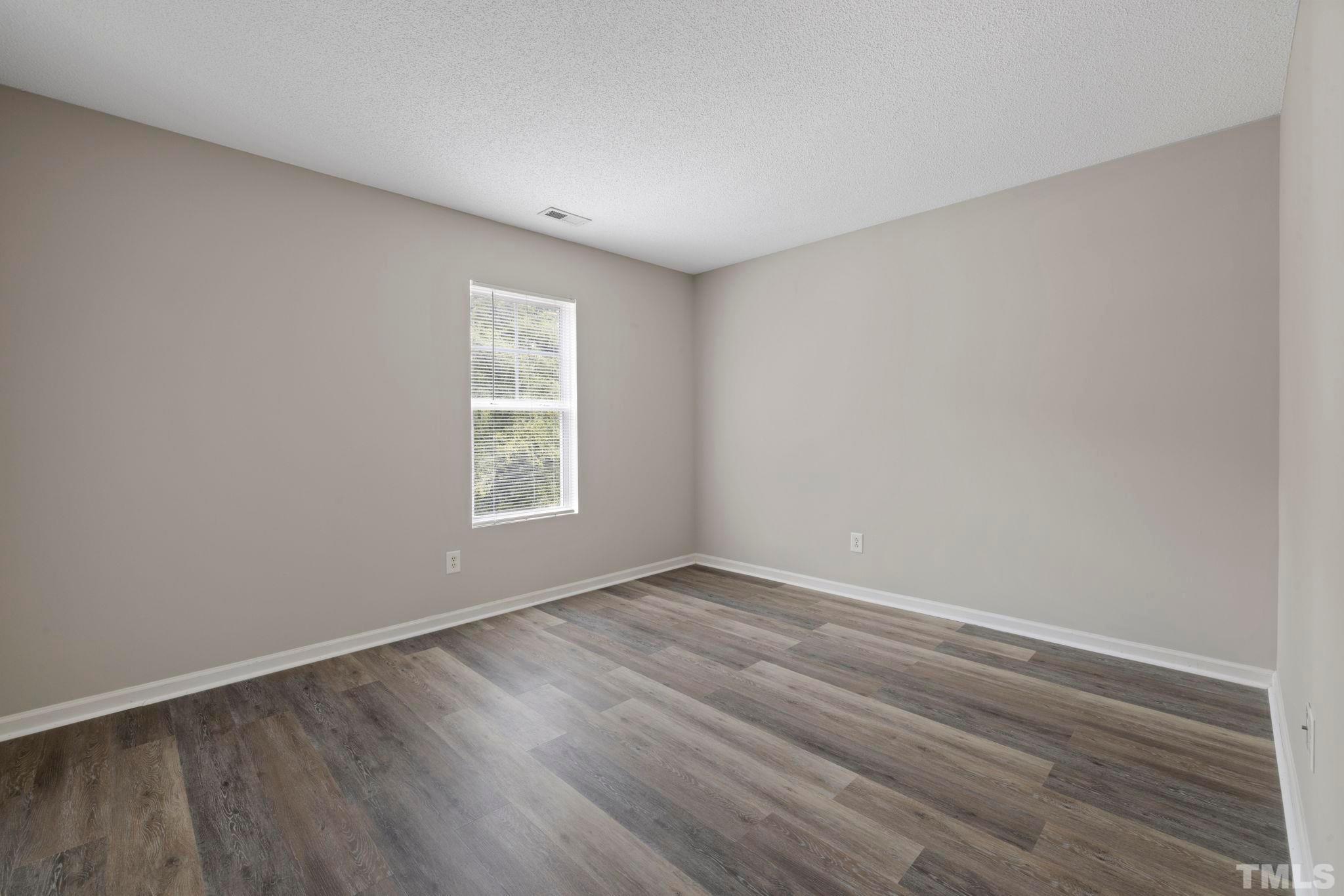 3519 Mountain Brook Circle Durham, NC 27704 - Photo 12 of 24 a view of an empty room with wooden floor and a window