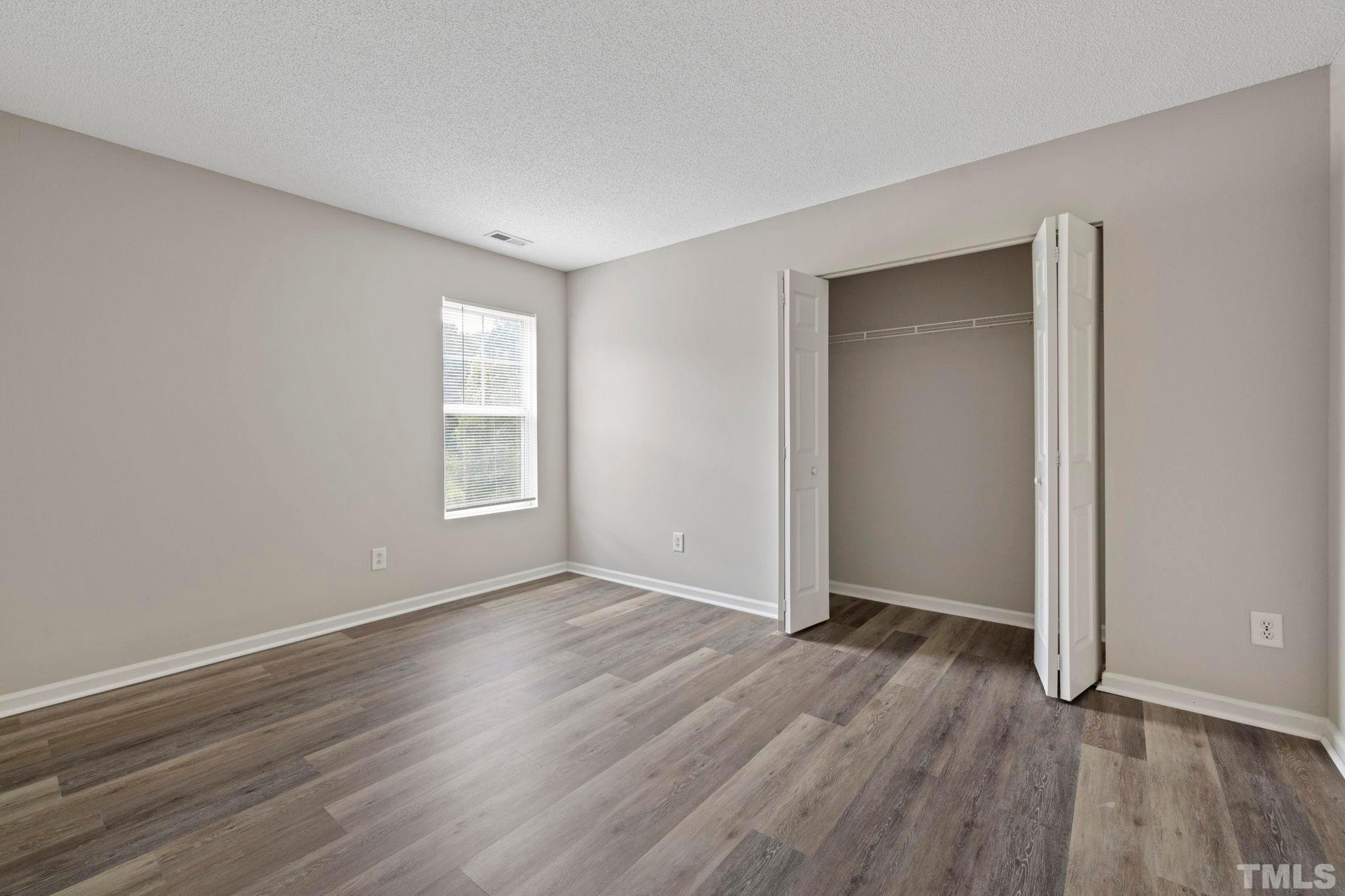 3519 Mountain Brook Circle Durham, NC 27704 - Photo 15 of 24 a view of an empty room with wooden floor and a window
