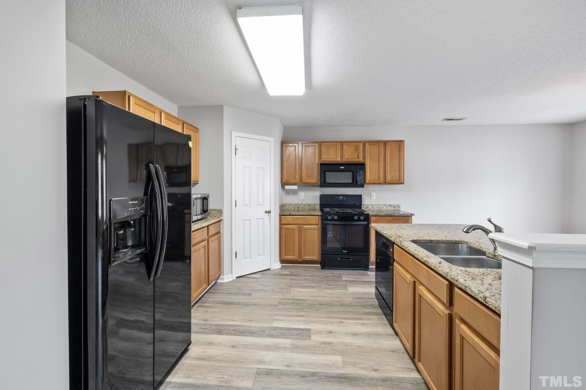 3519 Mountain Brook Circle Durham, NC 27704 - Photo 3 of 24 a kitchen with a refrigerator a sink and a stove