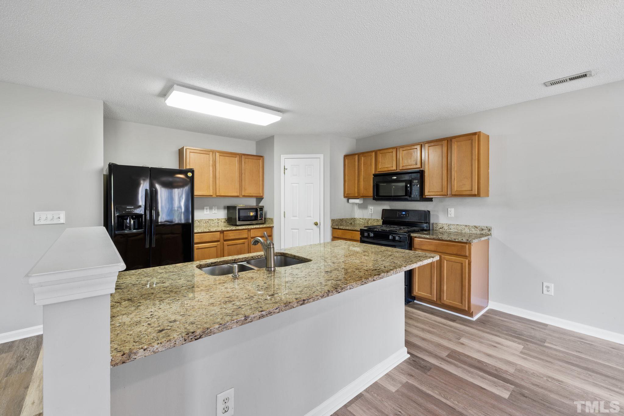 3519 Mountain Brook Circle Durham, NC 27704 - Photo 4 of 24 a kitchen with a stove a sink and a microwave