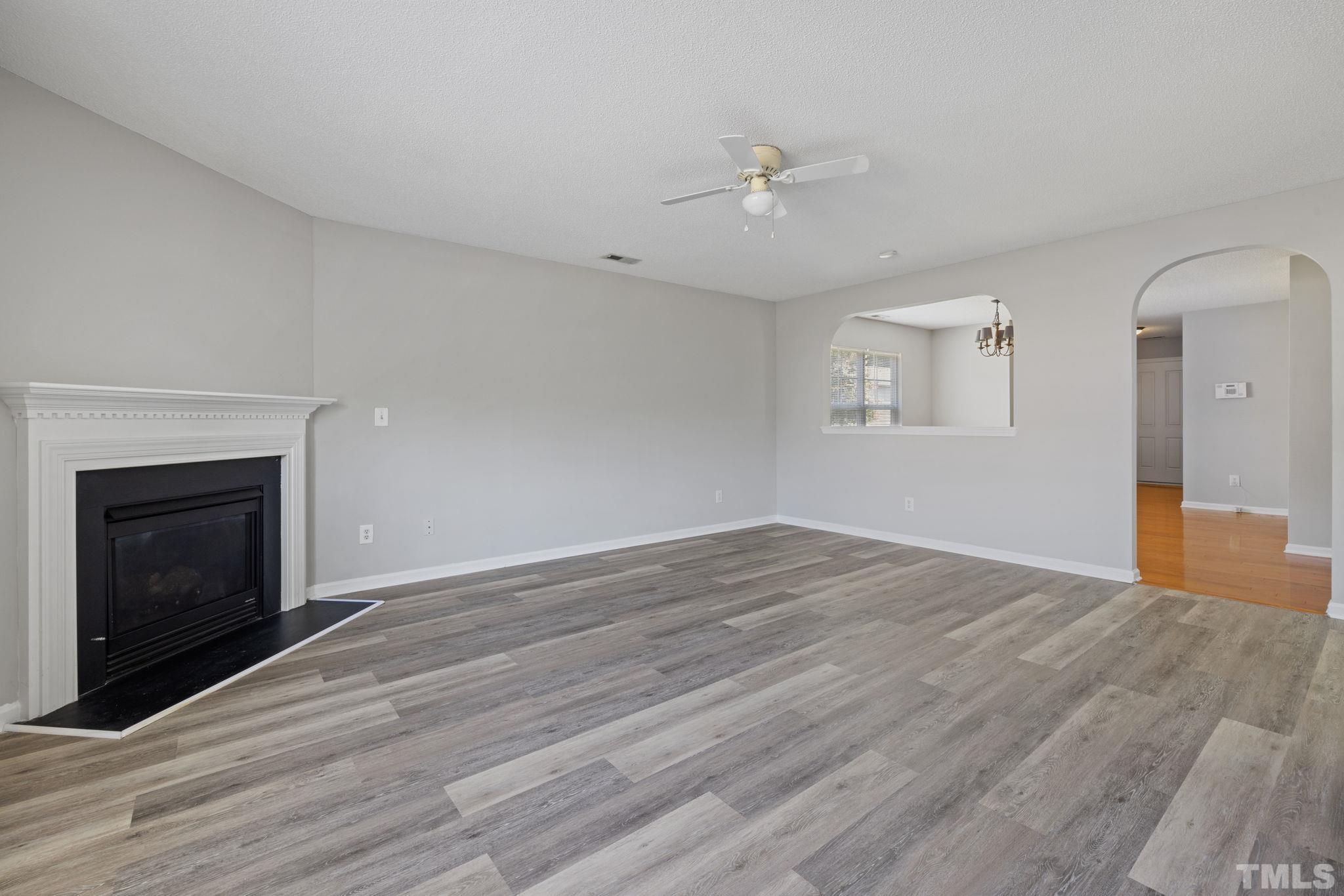 3519 Mountain Brook Circle Durham, NC 27704 - Photo 7 of 24 an empty room with wooden floor and fireplace