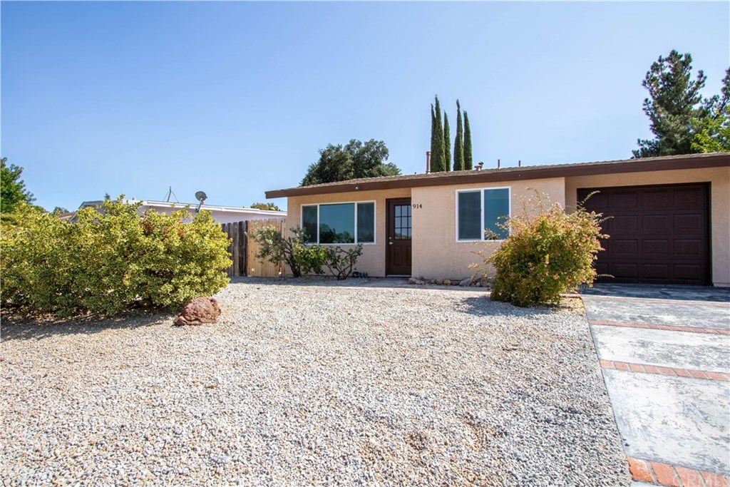 front view of a house with a yard and potted plants