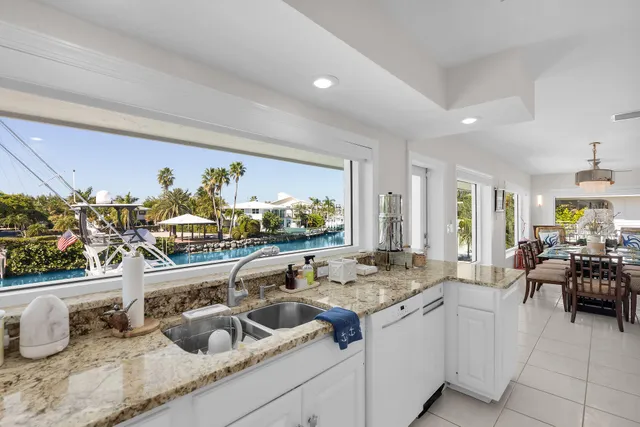 a view of a kitchen with kitchen island granite countertop a sink and a refrigerator