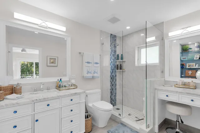 a bathroom with a granite countertop sink toilet a large mirror a vanity and shower