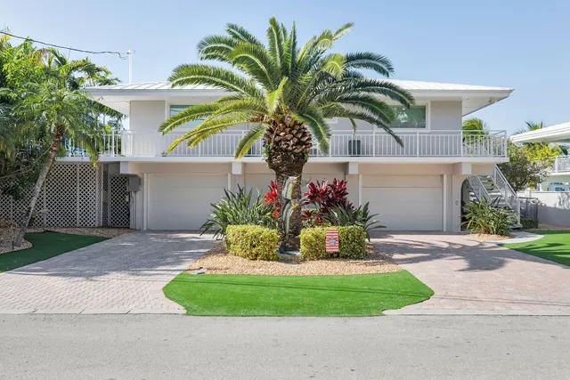 a view of a house with a yard and potted plants