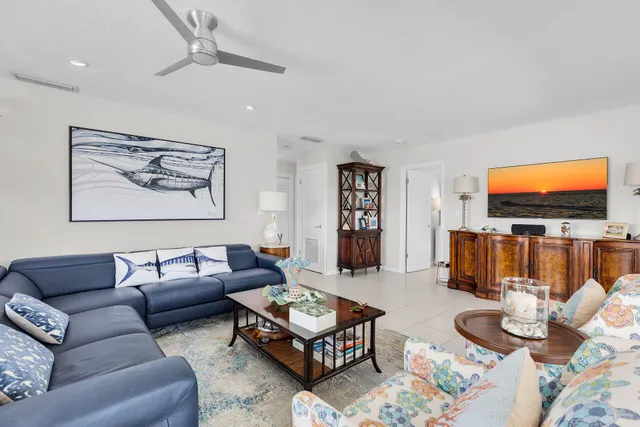 a living room with furniture a flat screen tv and a table