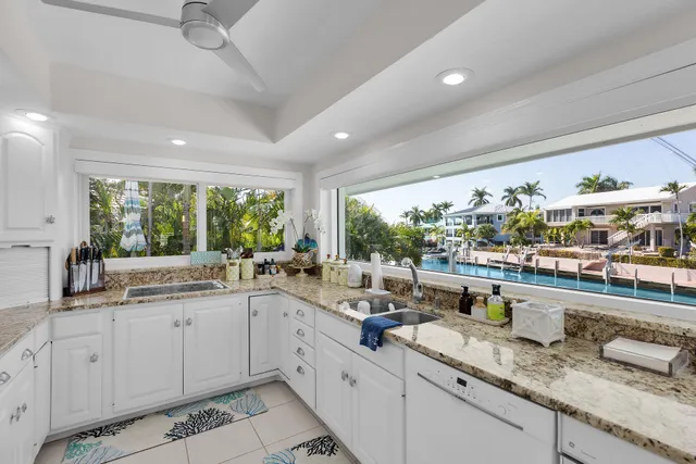 a large white kitchen with a lot of counter space and a wooden floor