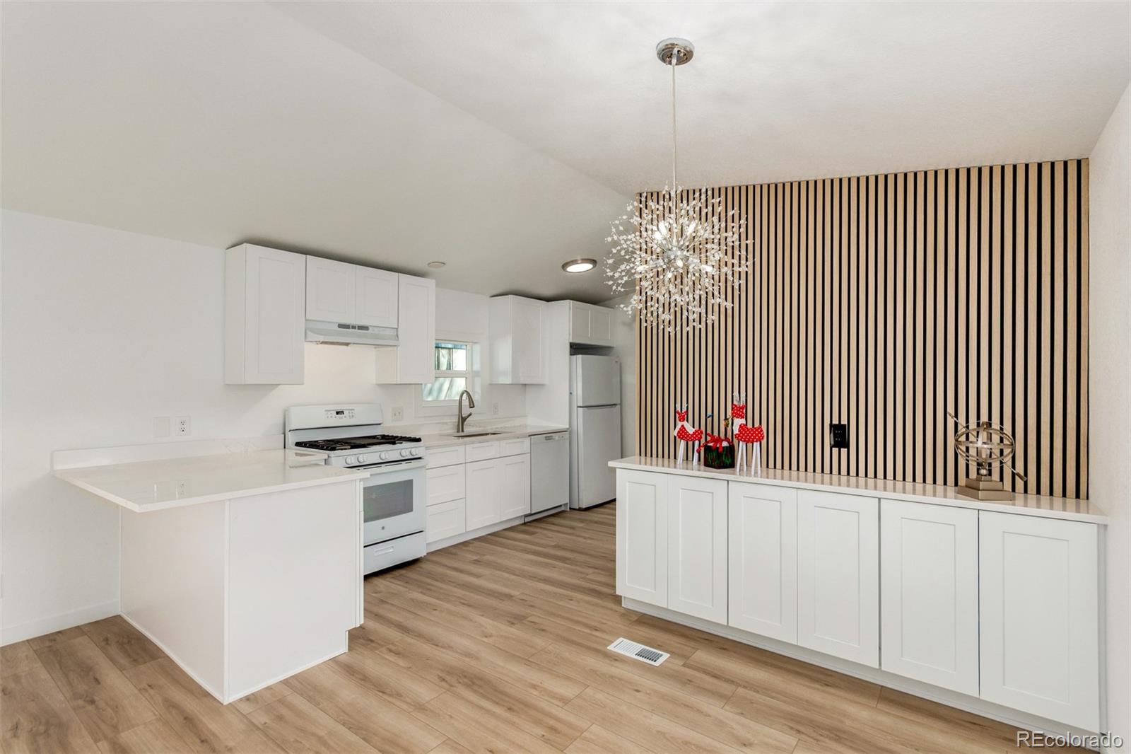 8466 Adams Way Denver, CO 80229 - Photo 14 of 31 a kitchen with white cabinets and sink