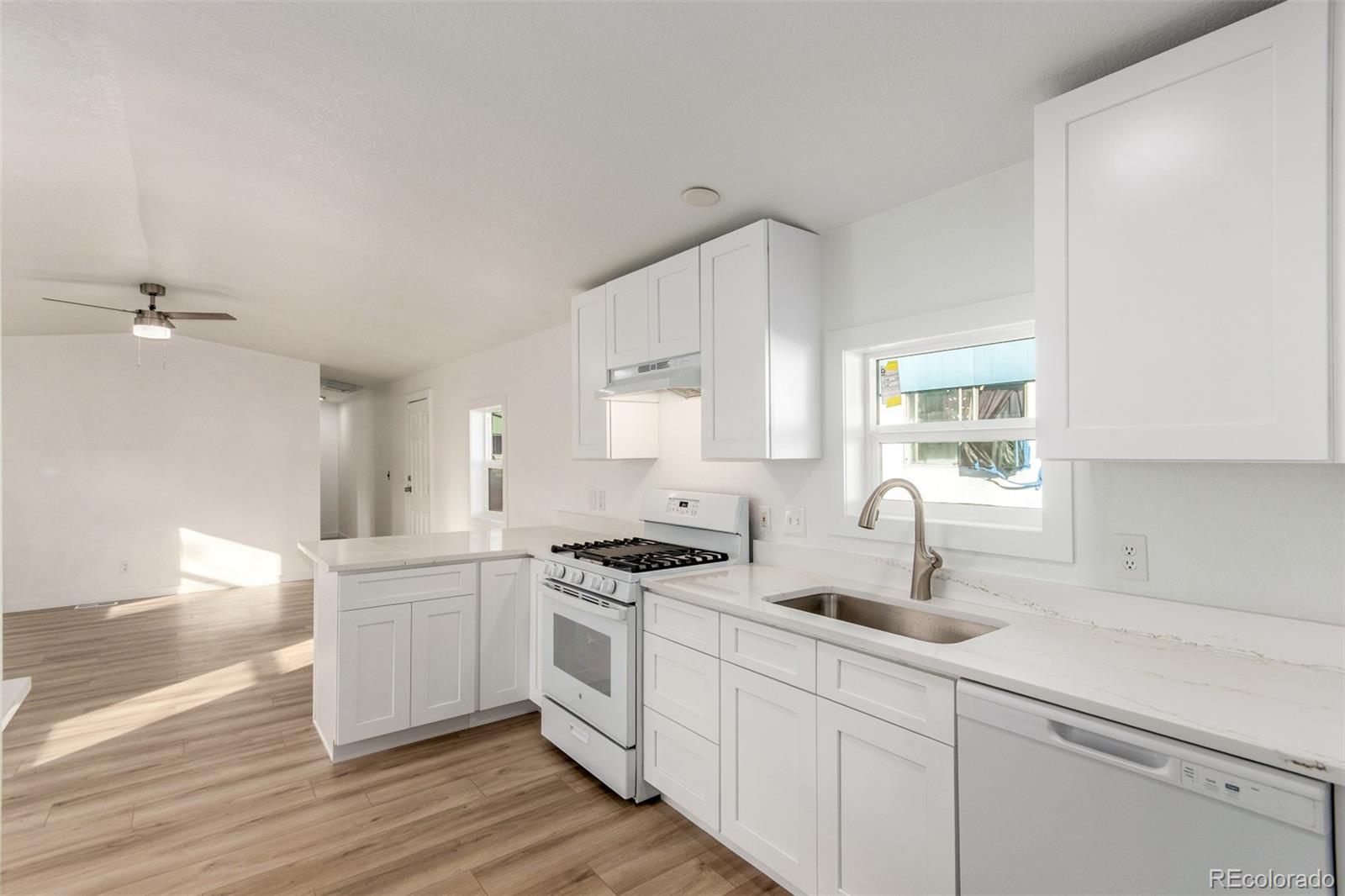 8466 Adams Way Denver, CO 80229 - Photo 17 of 31 a kitchen with sink cabinets and window