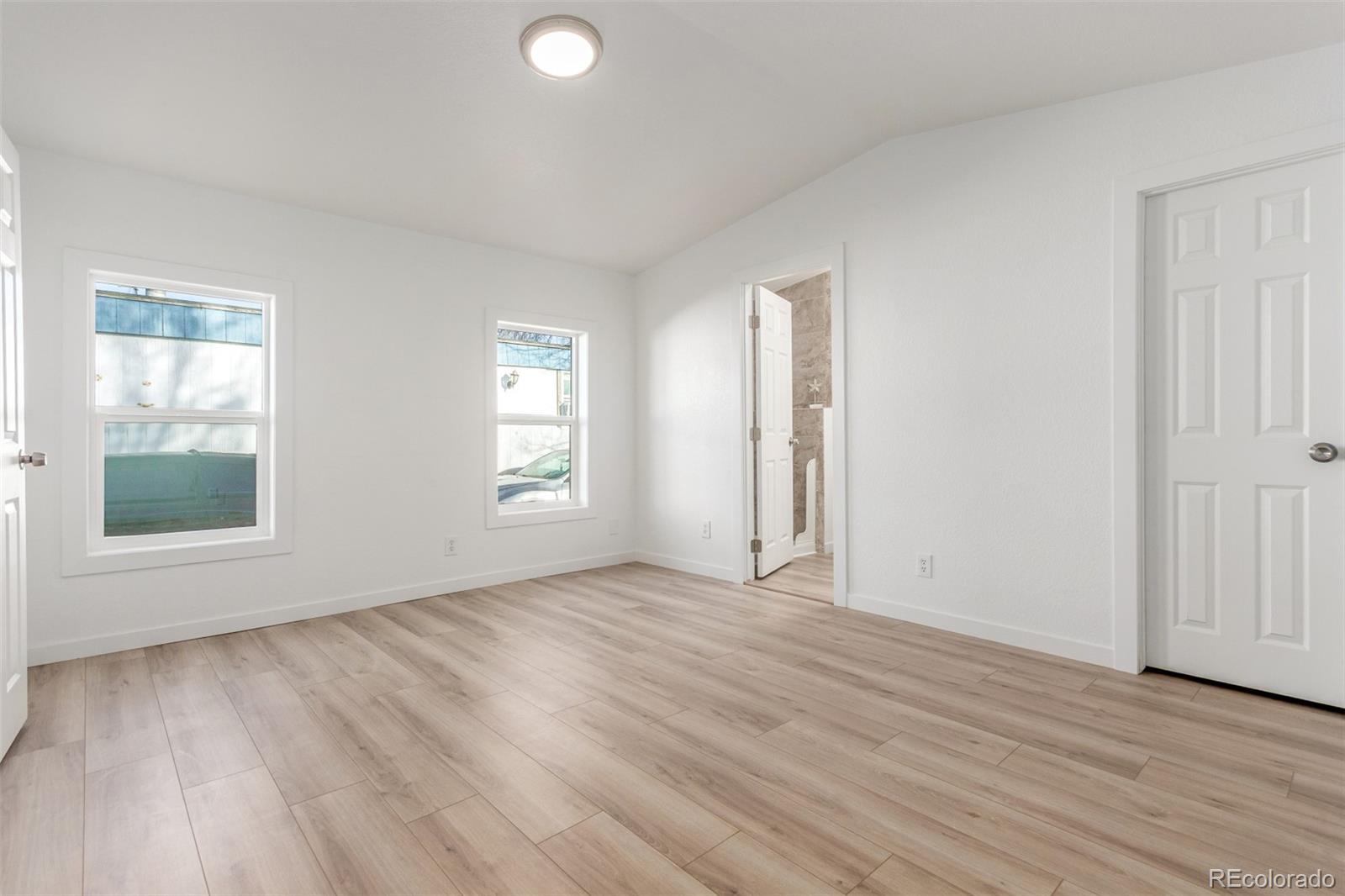 8466 Adams Way Denver, CO 80229 - Photo 20 of 31 an empty room with wooden floor and windows
