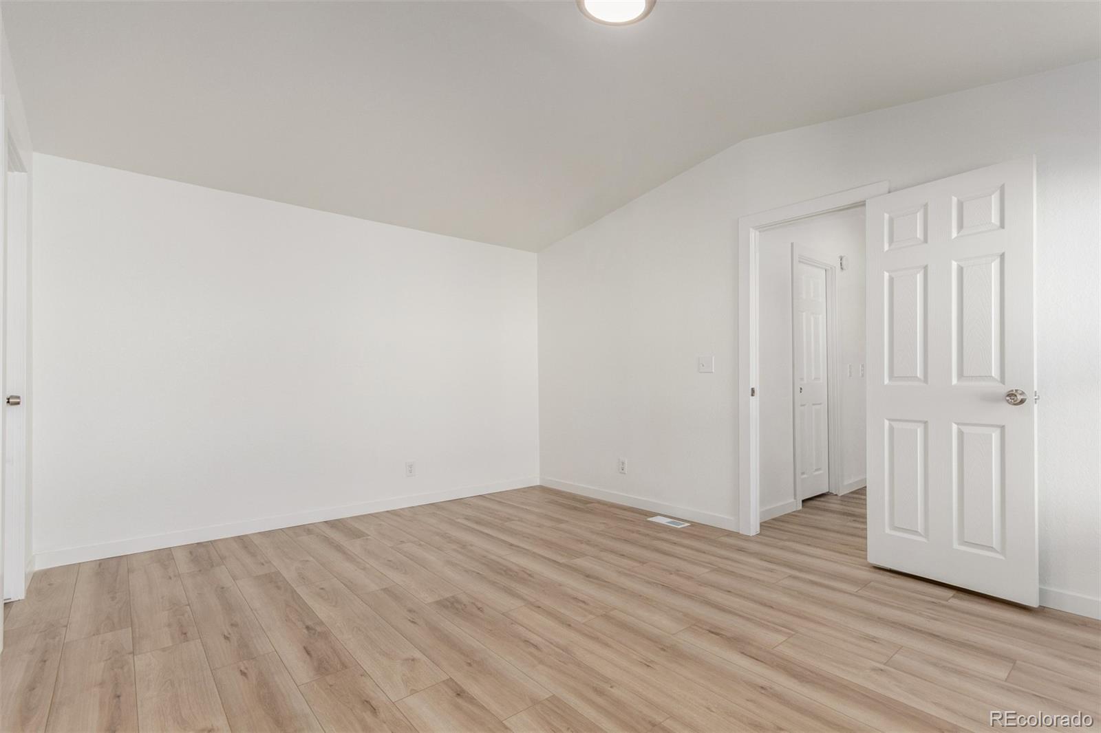 8466 Adams Way Denver, CO 80229 - Photo 22 of 31 a view of an empty room with wooden floor