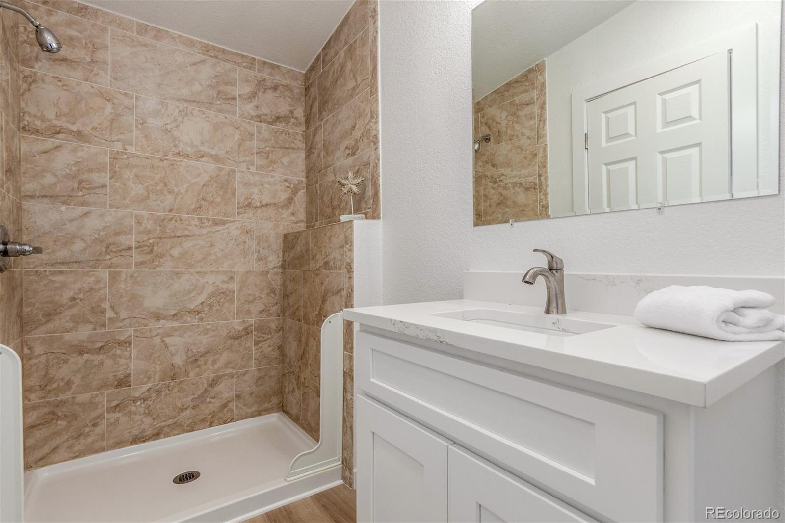 8466 Adams Way Denver, CO 80229 - Photo 24 of 31 a bathroom with a sink and a mirror