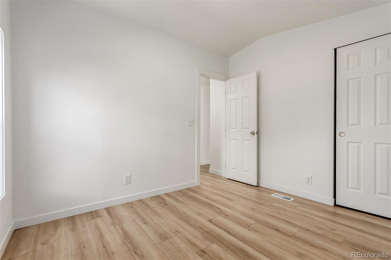 8466 Adams Way Denver, CO 80229 - Photo 27 of 31 a view of an empty room with wooden floor