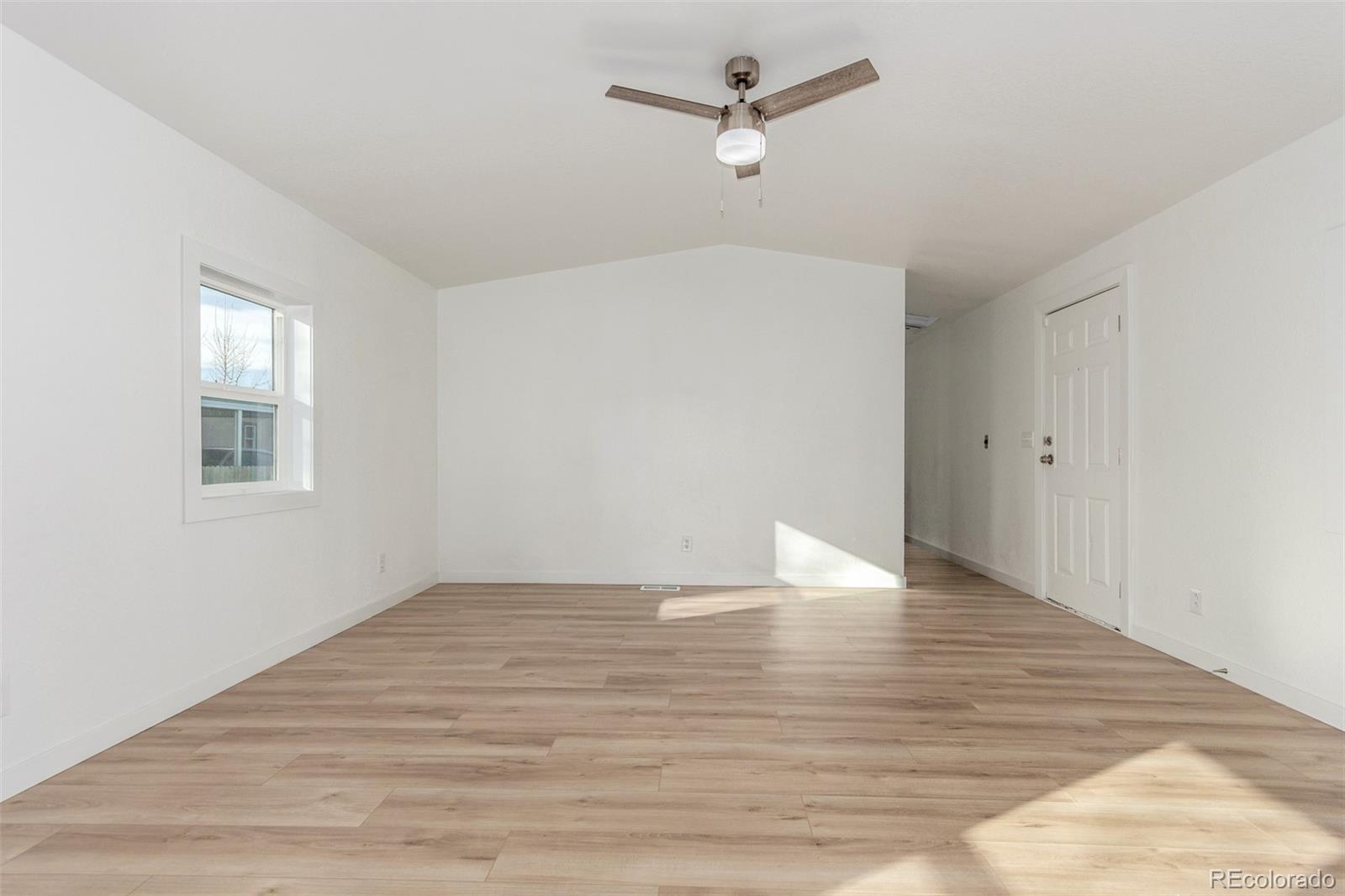 8466 Adams Way Denver, CO 80229 - Photo 9 of 31 a view of empty room with wooden floor and ceiling fan