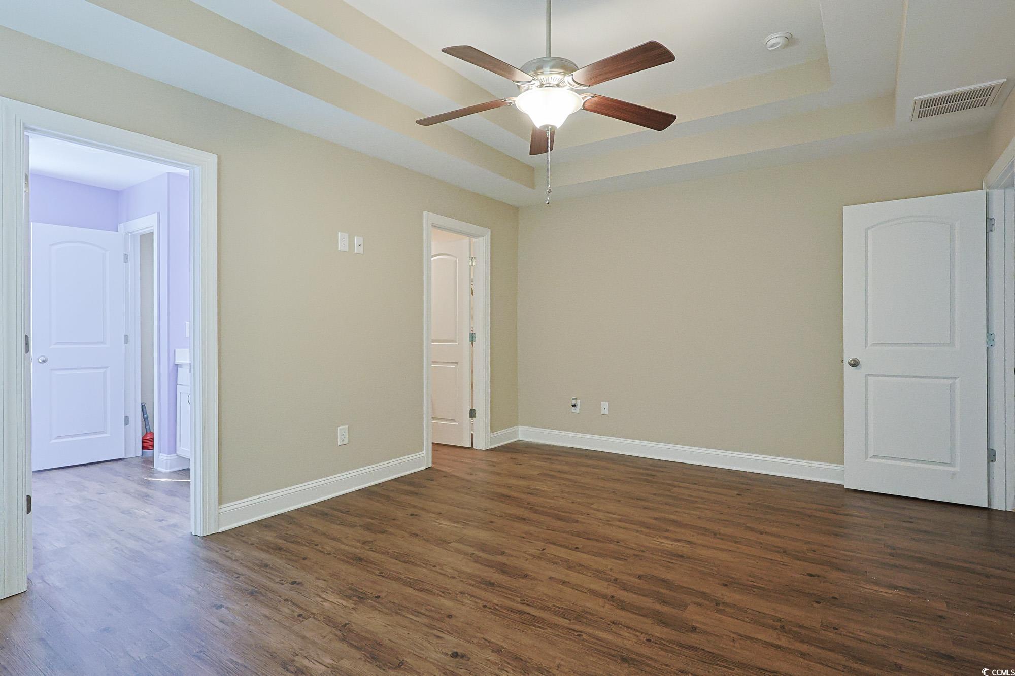 13 Daniel Morrall Lane Georgetown, SC 29440 - Photo 12 of 30 Unfurnished bedroom with a tray ceiling, dark wood-style floors, and ceiling fan