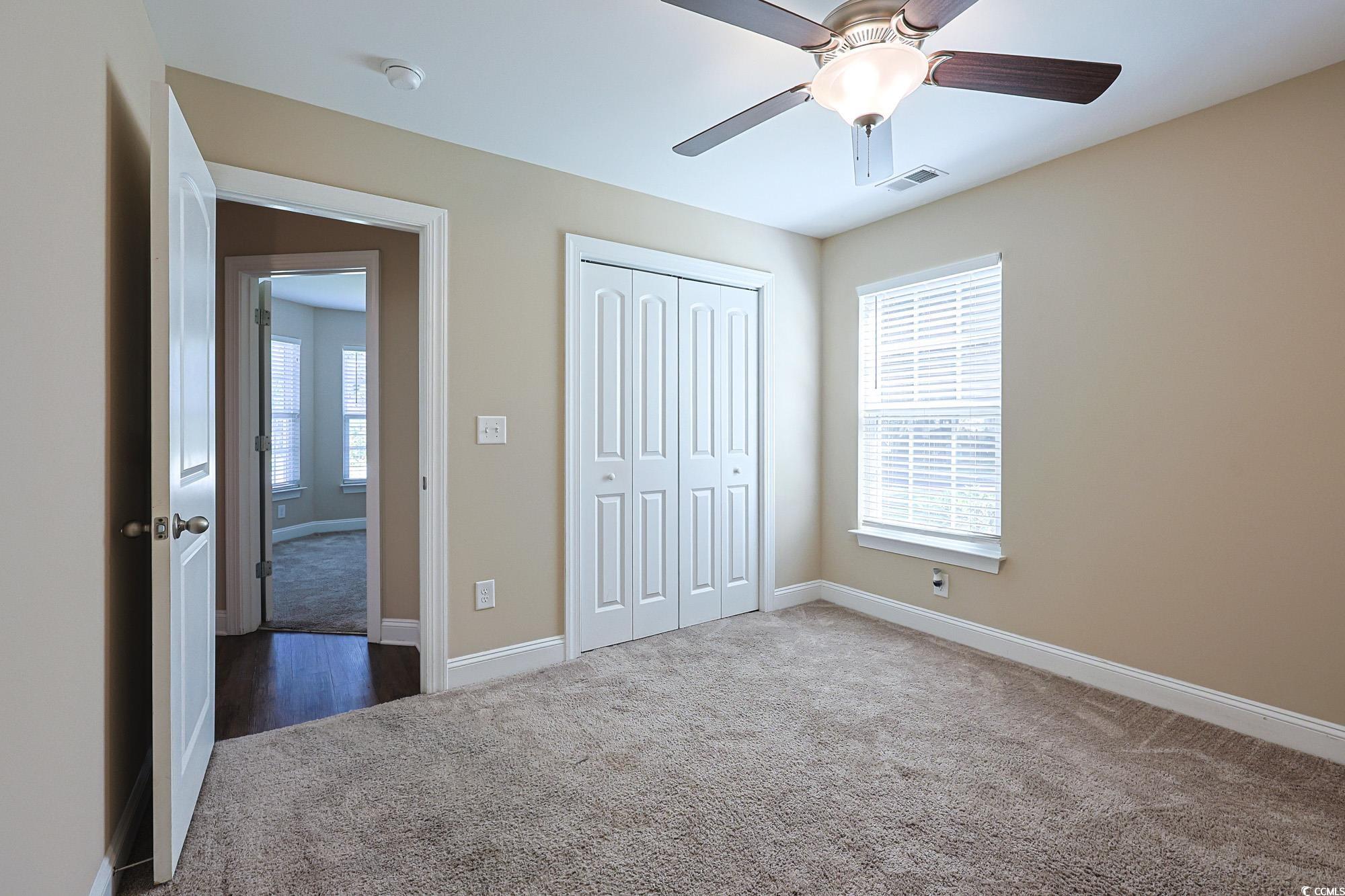 13 Daniel Morrall Lane Georgetown, SC 29440 - Photo 17 of 30 Unfurnished bedroom with dark carpet, multiple windows, a closet, and ceiling fan