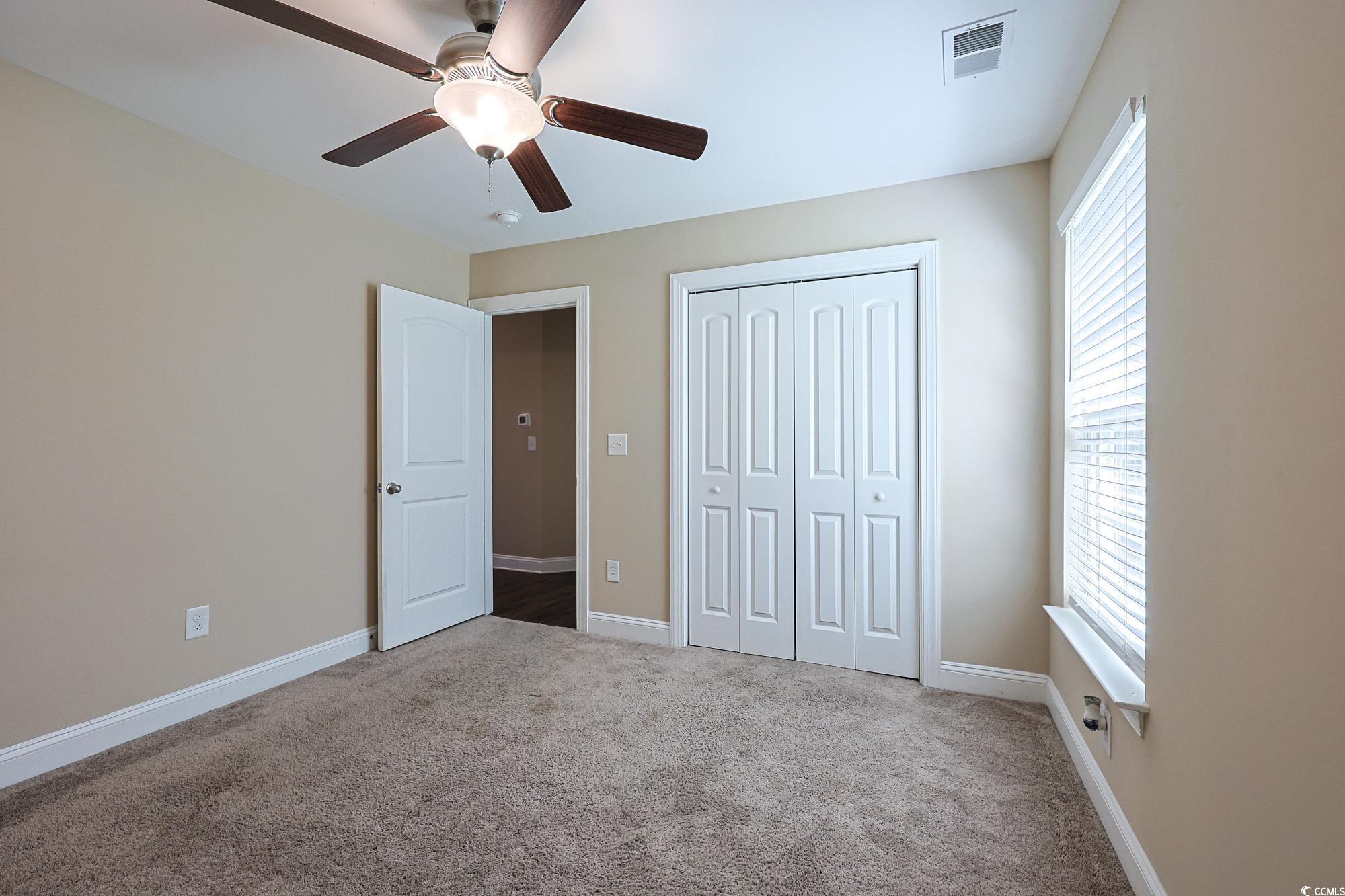 13 Daniel Morrall Lane Georgetown, SC 29440 - Photo 18 of 30 Unfurnished bedroom with carpet flooring, a ceiling fan, and a closet