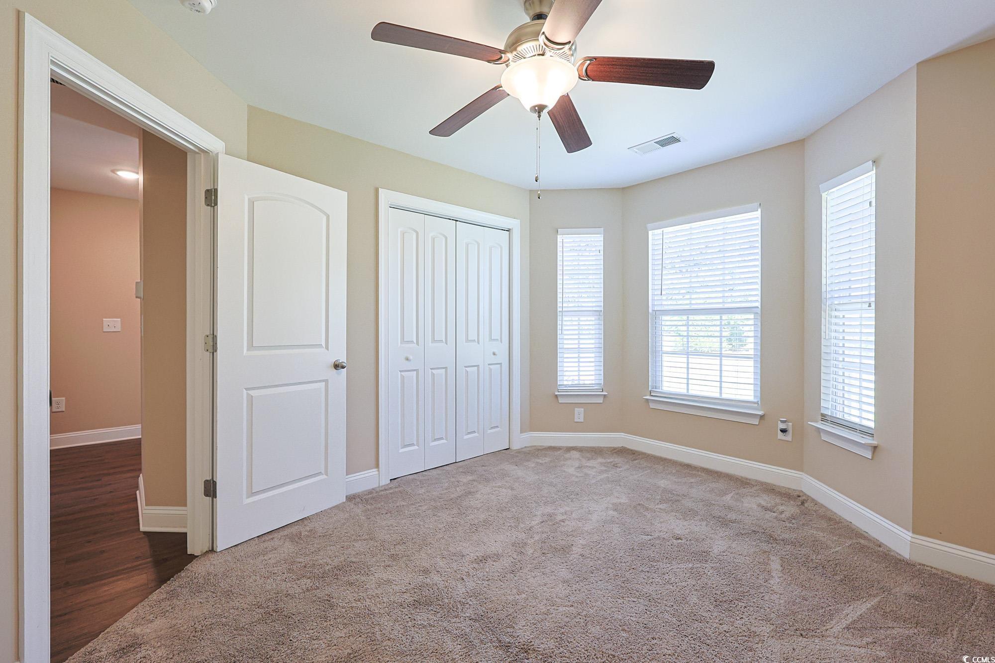 13 Daniel Morrall Lane Georgetown, SC 29440 - Photo 23 of 30 Unfurnished bedroom featuring carpet floors, a ceiling fan, and a closet