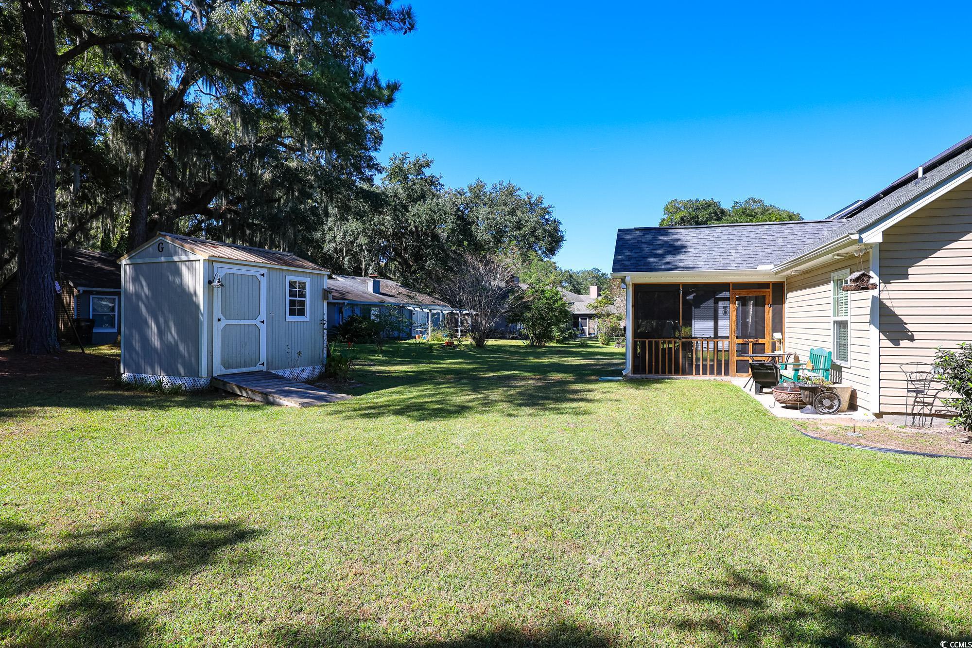 13 Daniel Morrall Lane Georgetown, SC 29440 - Photo 3 of 30 View of grassy yard featuring a sunroom and a shed