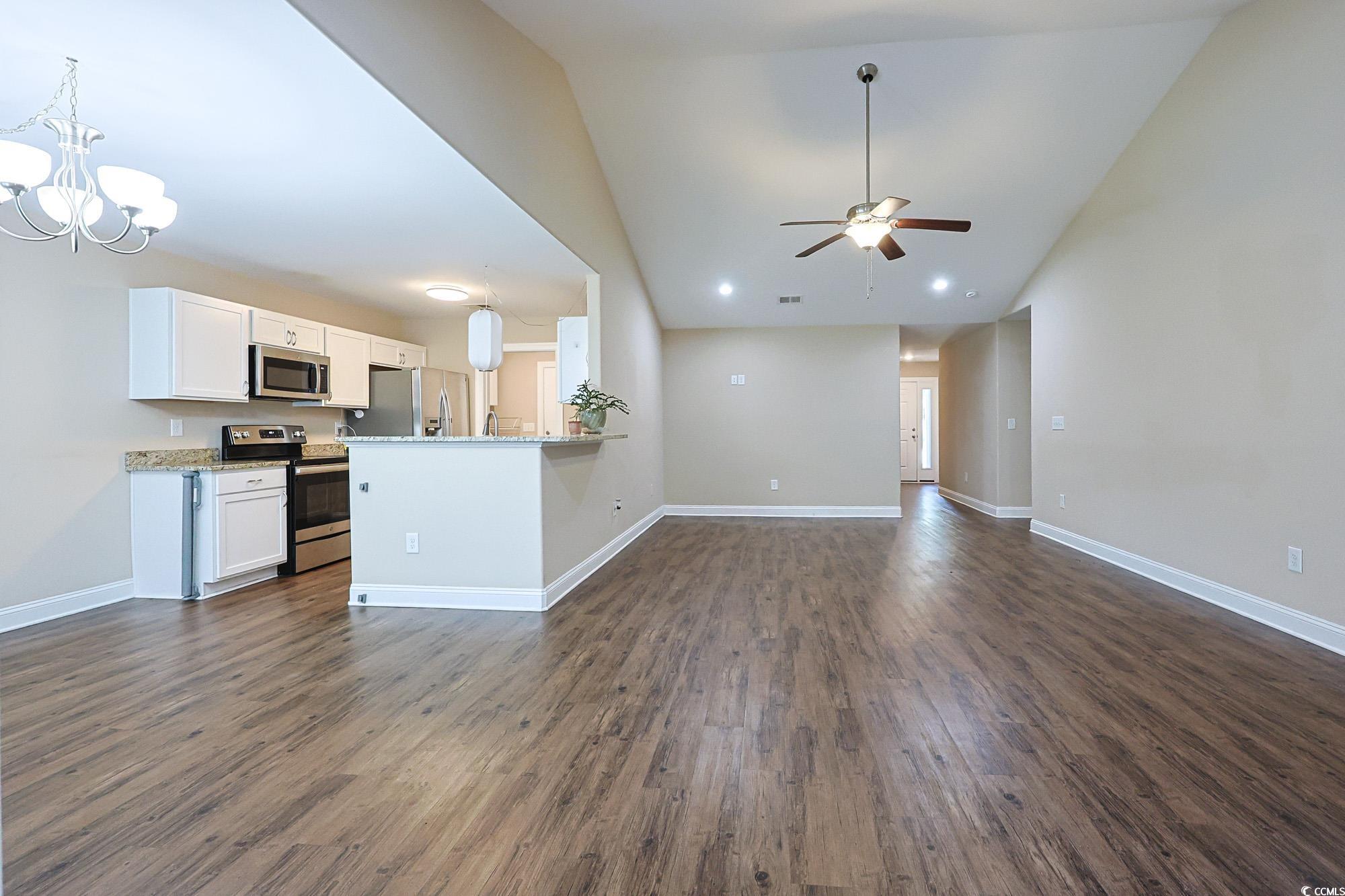 13 Daniel Morrall Lane Georgetown, SC 29440 - Photo 4 of 30 Unfurnished living room with a chandelier, dark wood finished floors, high vaulted ceiling, and a ceiling fan