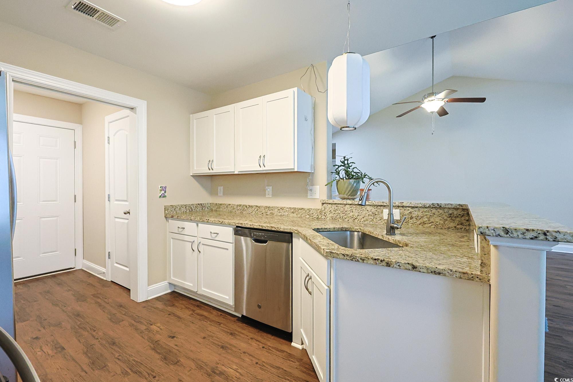13 Daniel Morrall Lane Georgetown, SC 29440 - Photo 9 of 30 Kitchen featuring white cabinetry, dark wood-type flooring, a peninsula, appliances with stainless steel finishes, and vaulted ceiling