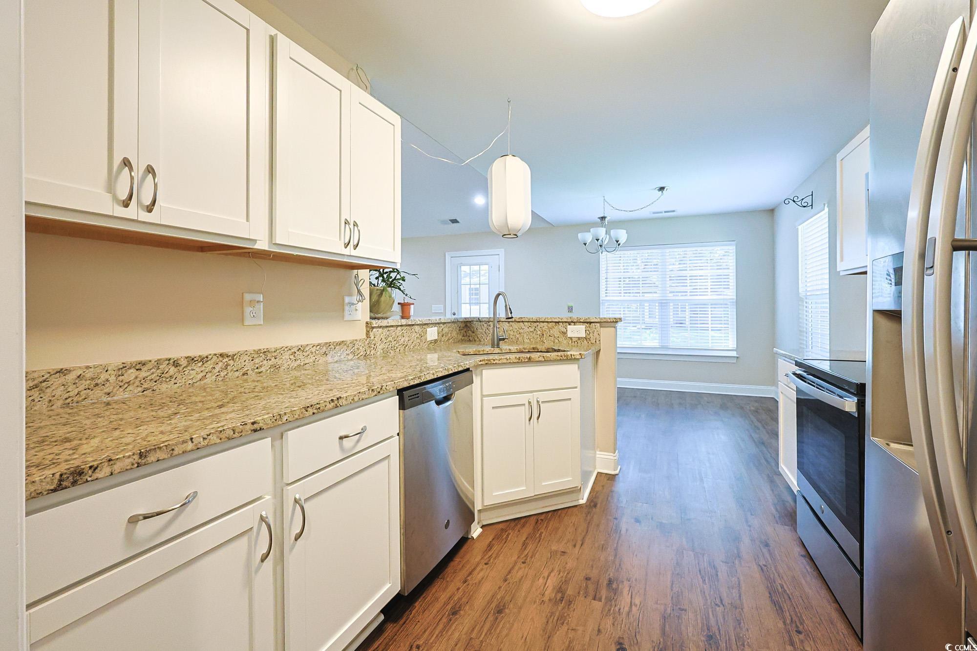 13 Daniel Morrall Lane Georgetown, SC 29440 - Photo 10 of 30 Kitchen featuring white cabinets, stainless steel appliances, dark wood-style floors, and light stone countertops