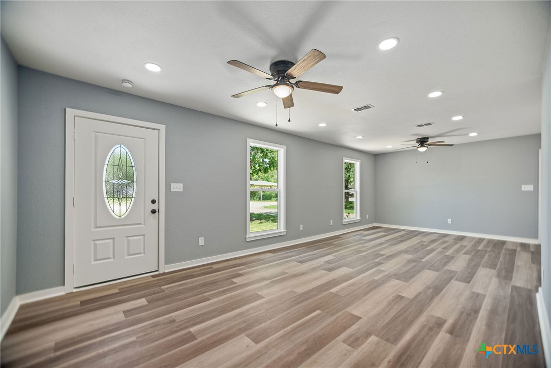 210 Travis Street Port Lavaca, TX 77979 - Photo 2 of 28 VInyl plank flooring, recessed lighting, and large beautiful windows let the sunlight shine through.