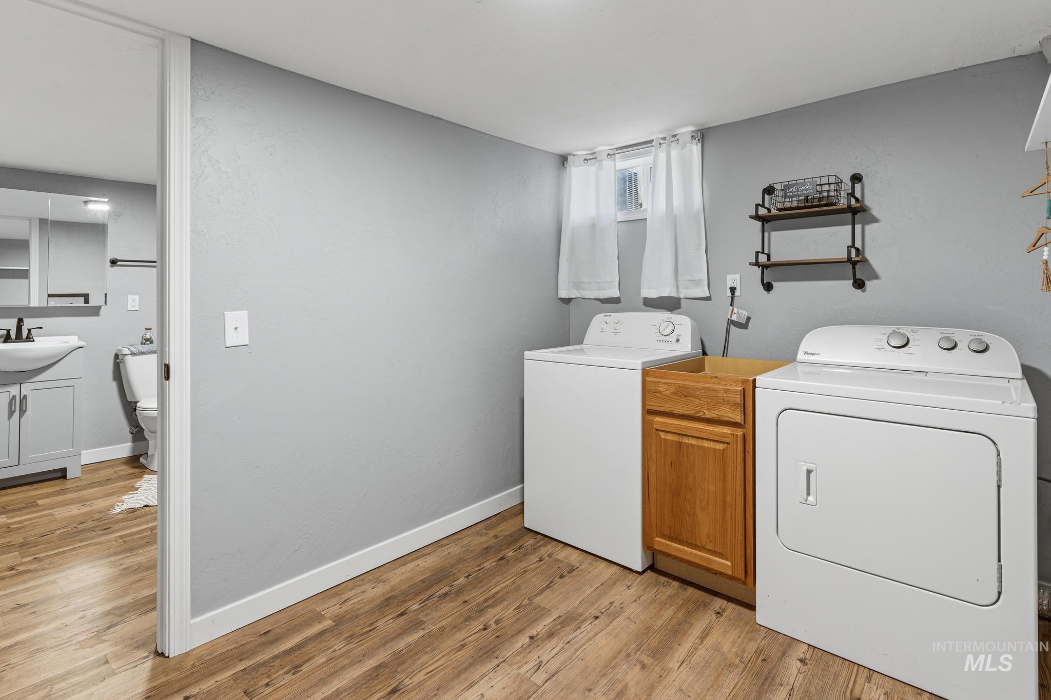 619 Thain Road Lewiston, ID 83501 - Photo 12 of 44 Laundry area featuring wood-finish flooring, light gray walls, and a small window