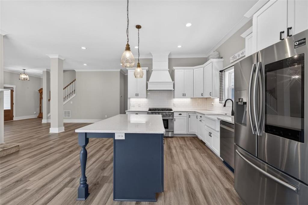 5118 Floyd Street Northeast Covington, GA 30014 - Photo 22 of 78 an open kitchen with kitchen island wooden floor granite counter tops and appliances