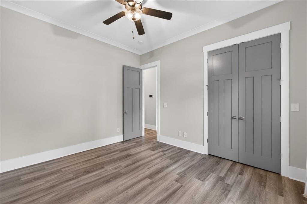 5118 Floyd Street Northeast Covington, GA 30014 - Photo 38 of 78 an empty room with wooden floor ceiling fan and windows