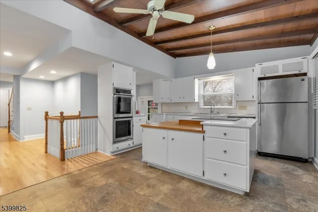 a kitchen with granite countertop a refrigerator and a sink
