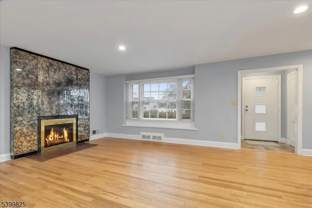 a view of an empty room with window and fire place