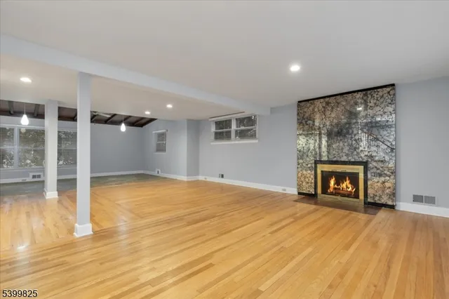 a view of an empty room with a fireplace and a window