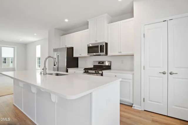 a kitchen with appliances a sink cabinets and a window