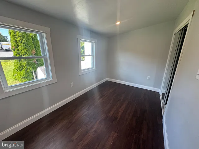 a view of a room with wooden floors and window