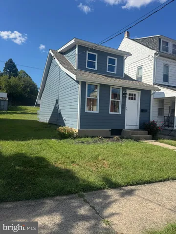 a view of a brick house next to a yard