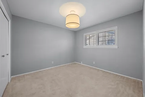 an empty room with a fan and a window
