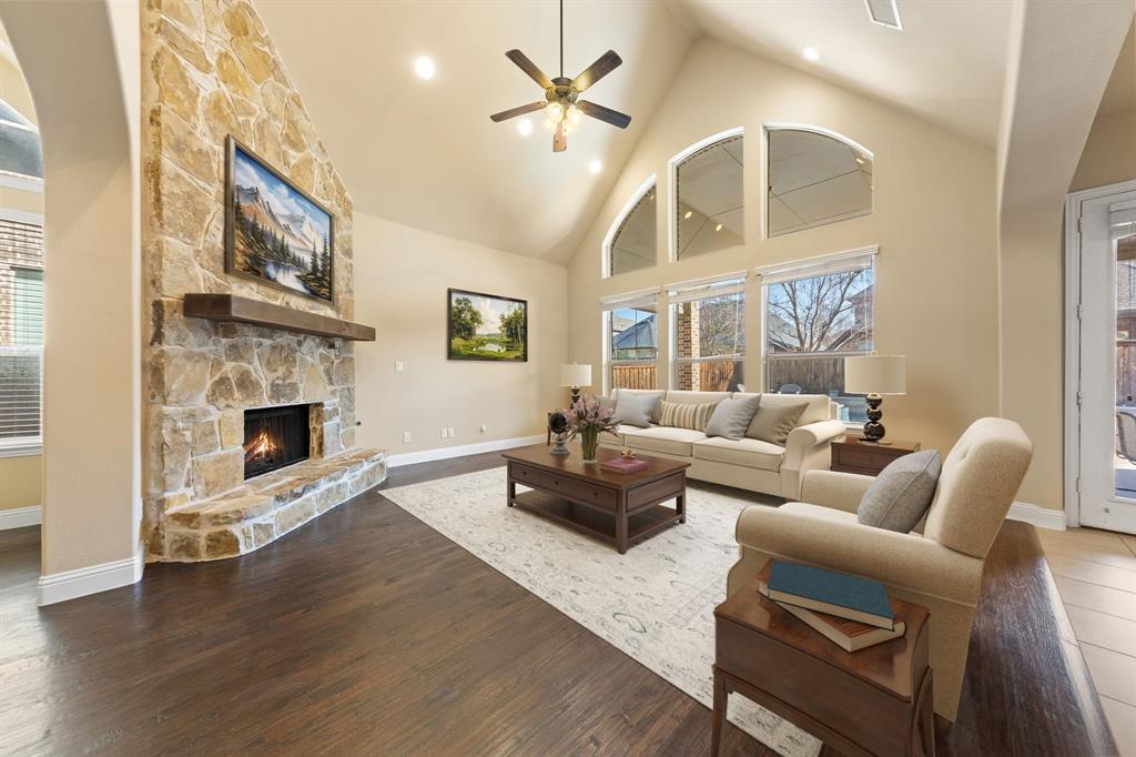 8336 Pitkin Road Frisco, TX 75036 - Photo 11 of 40 a living room with furniture a fireplace and a chandelier
