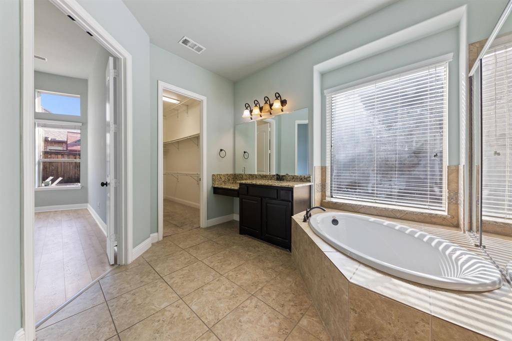 8336 Pitkin Road Frisco, TX 75036 - Photo 26 of 40 a spacious bathroom with a tub sink and mirror