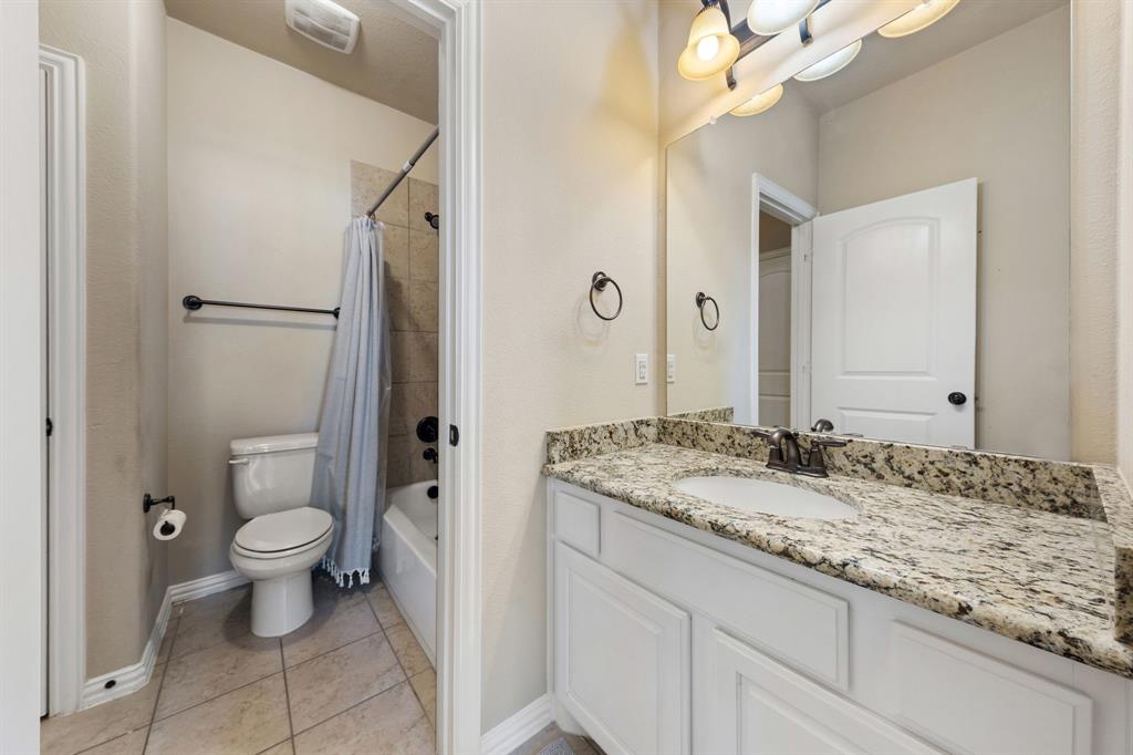 8336 Pitkin Road Frisco, TX 75036 - Photo 34 of 40 a bathroom with a granite countertop sink a toilet and a mirror