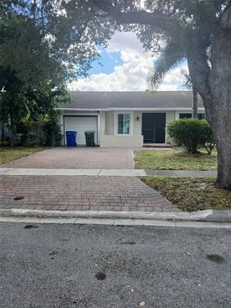 a view of a house with a yard and large tree