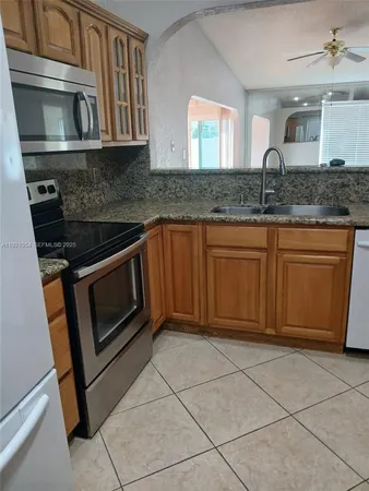 a kitchen with stainless steel appliances granite countertop a sink stove and cabinets