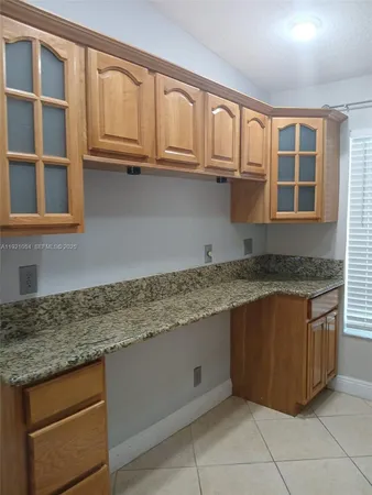 a kitchen with granite countertop a sink and cabinets