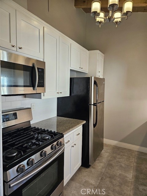 3315 Strongs Drive, Unit B Venice, CA 90292 - Photo 3 of 15 a kitchen with stainless steel appliances granite countertop a refrigerator stove and white cabinets