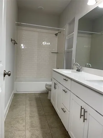 a bathroom with a double vanity sink a toilet and shower